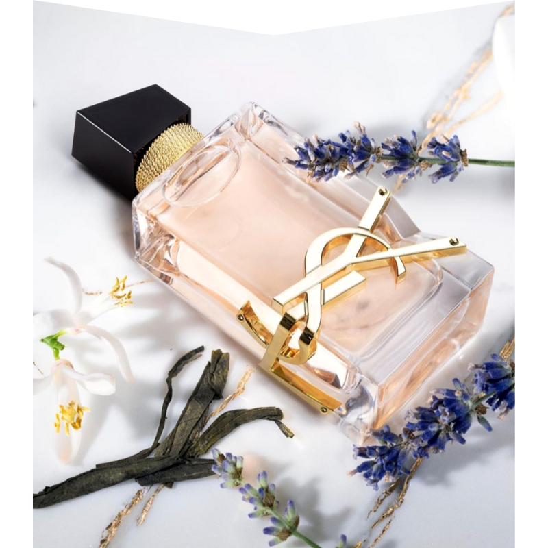 Perfume bottle with flowers surrounding it.