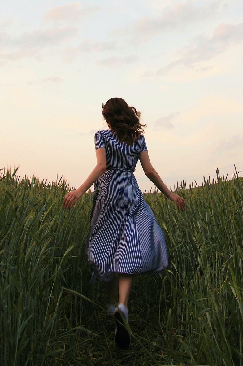 girl in dress running in feild