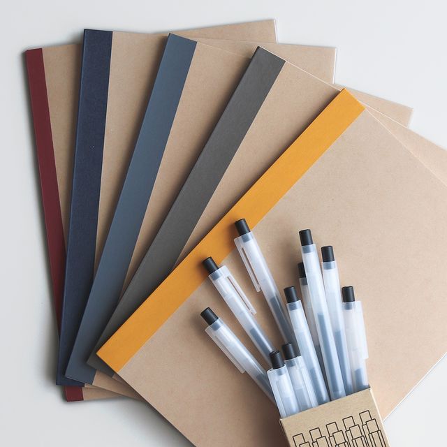 flat lay of fanned out notebooks and pens spilled out of a box