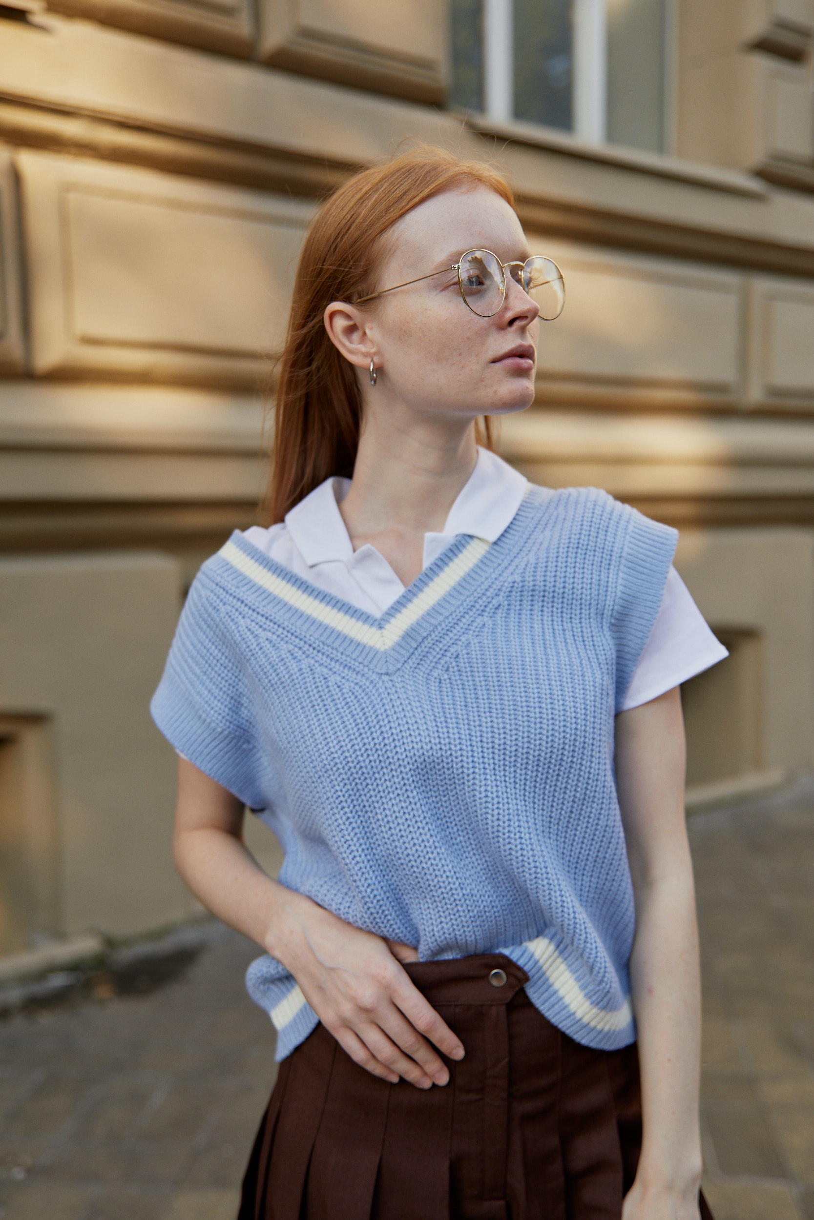 Girl with a blue sweater vest and brown skirt