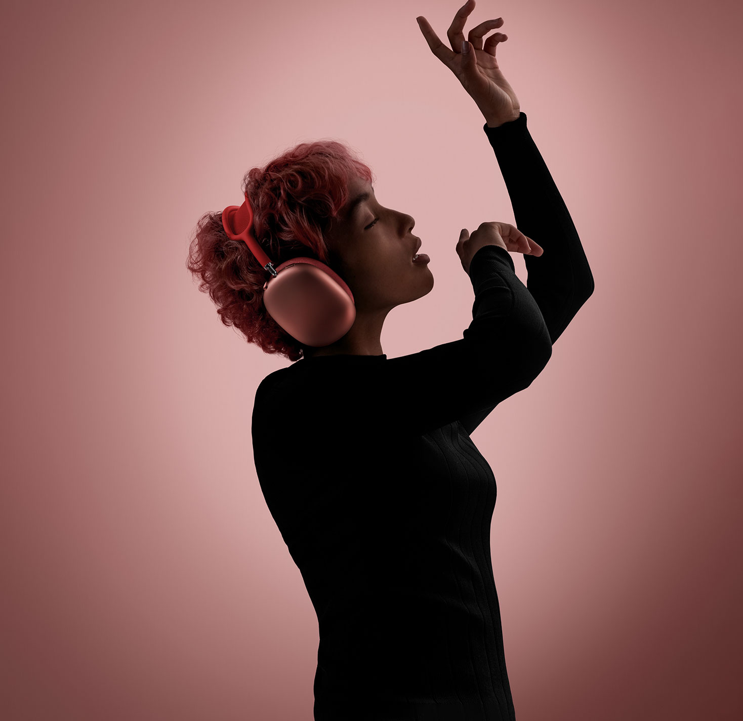 A person wearing pink headphones from Apple and dancing