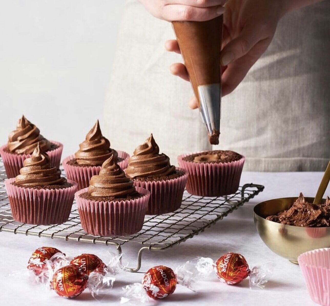 Chocolate cupcakes being frosted
