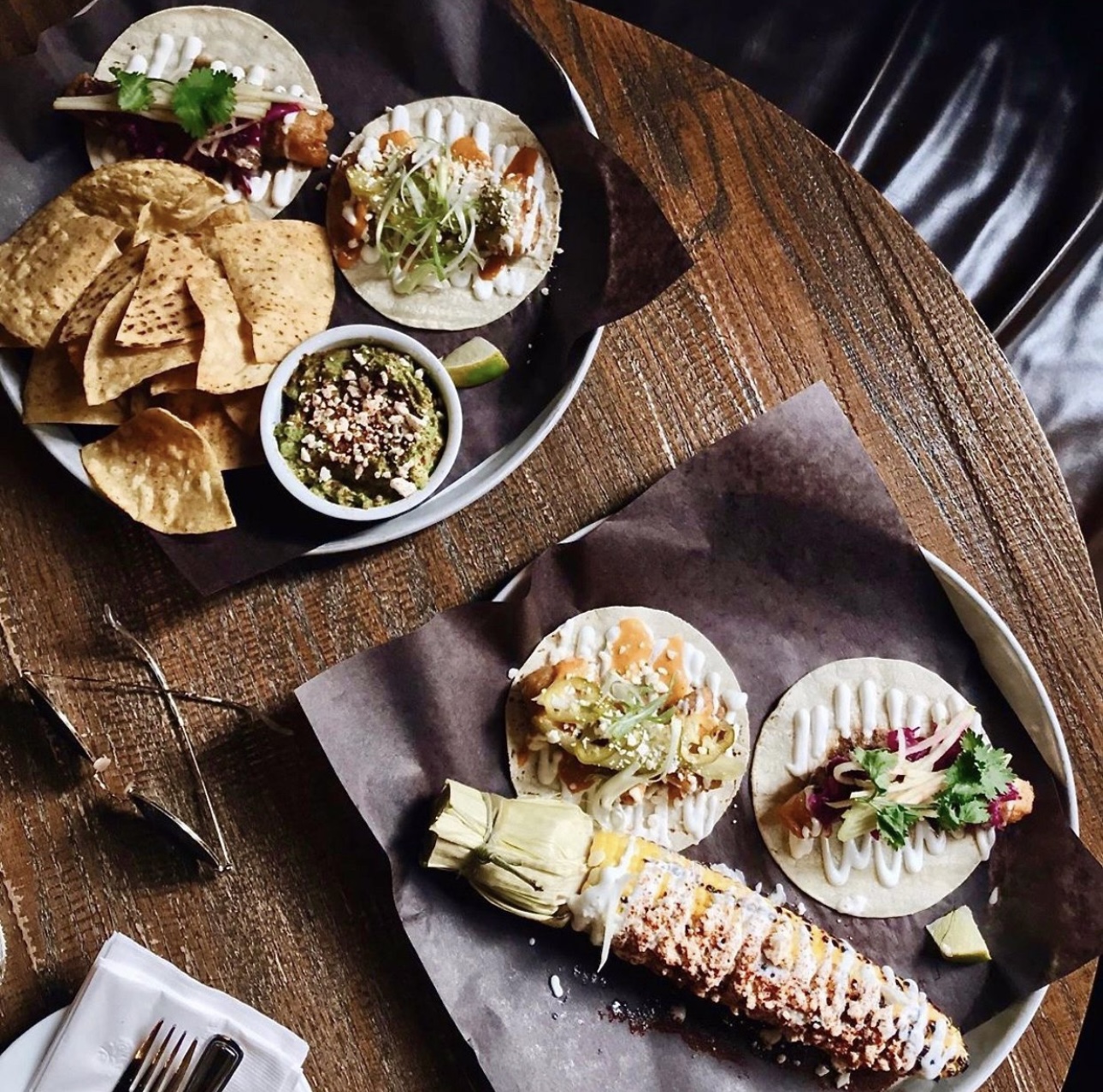 a table with tacos, chips and corn