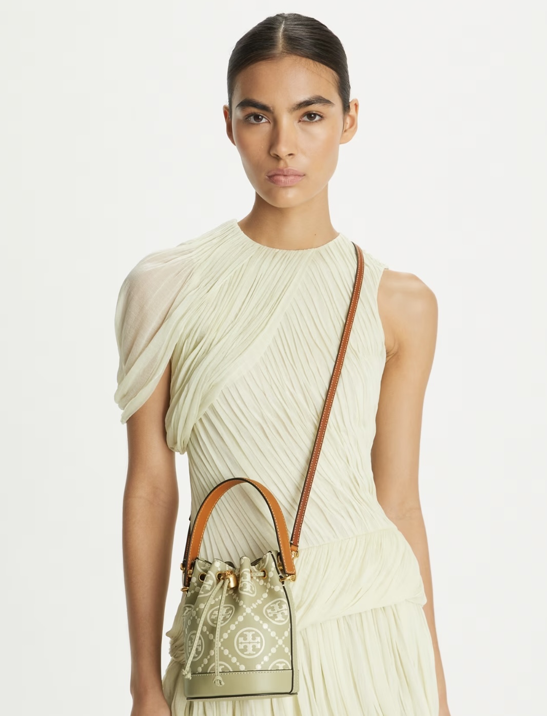 A woman wearing a cream coloured dress and purse