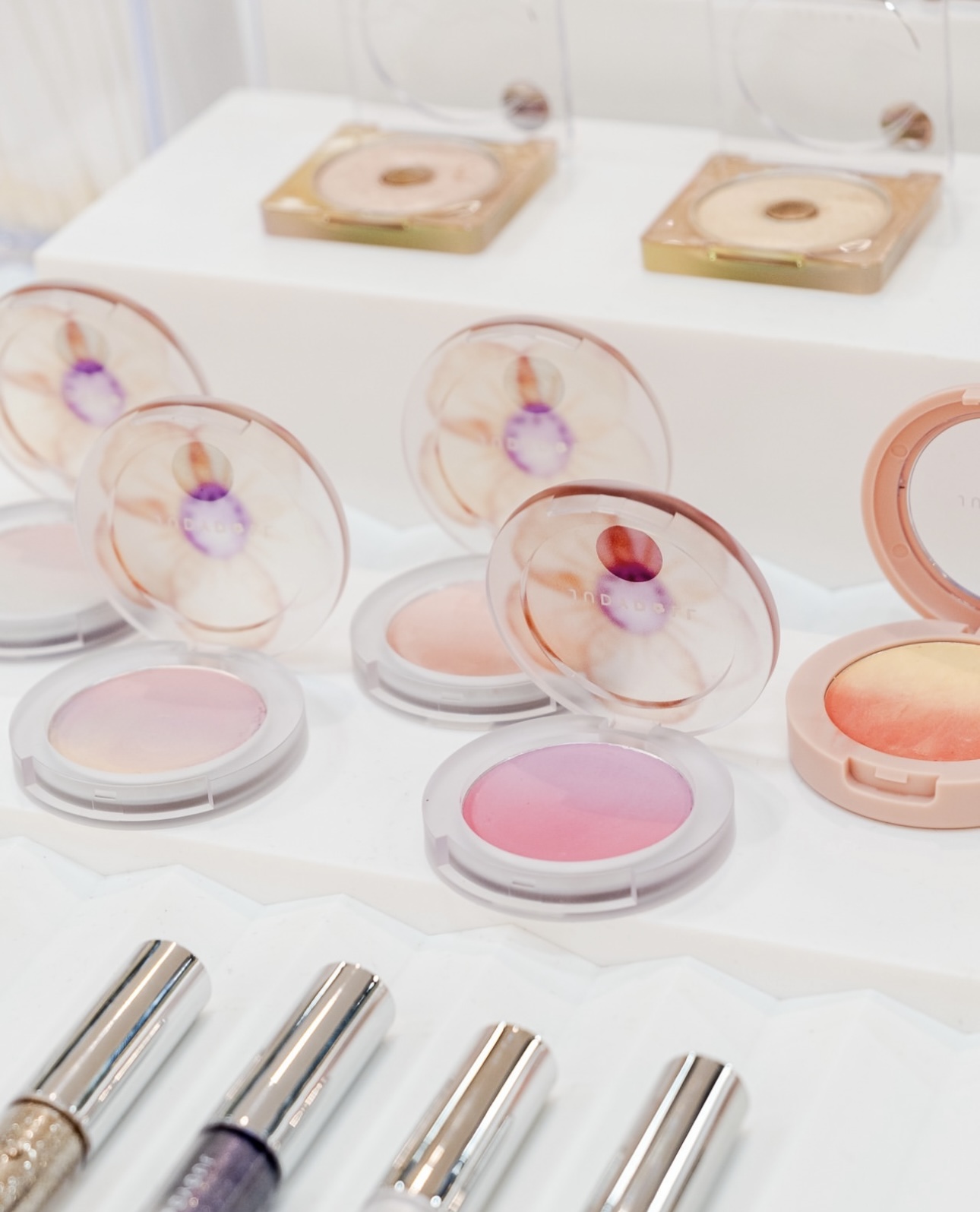 Various makeup powder cases and lipstick tubes