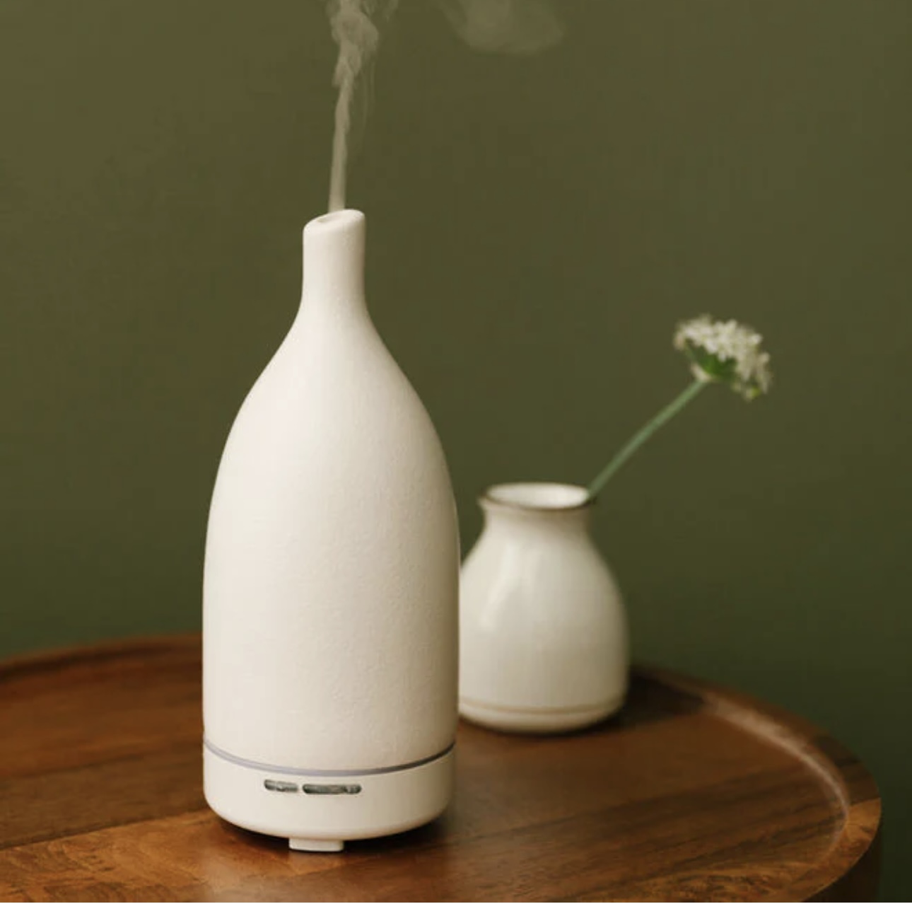 A white diffuser on a wooden table