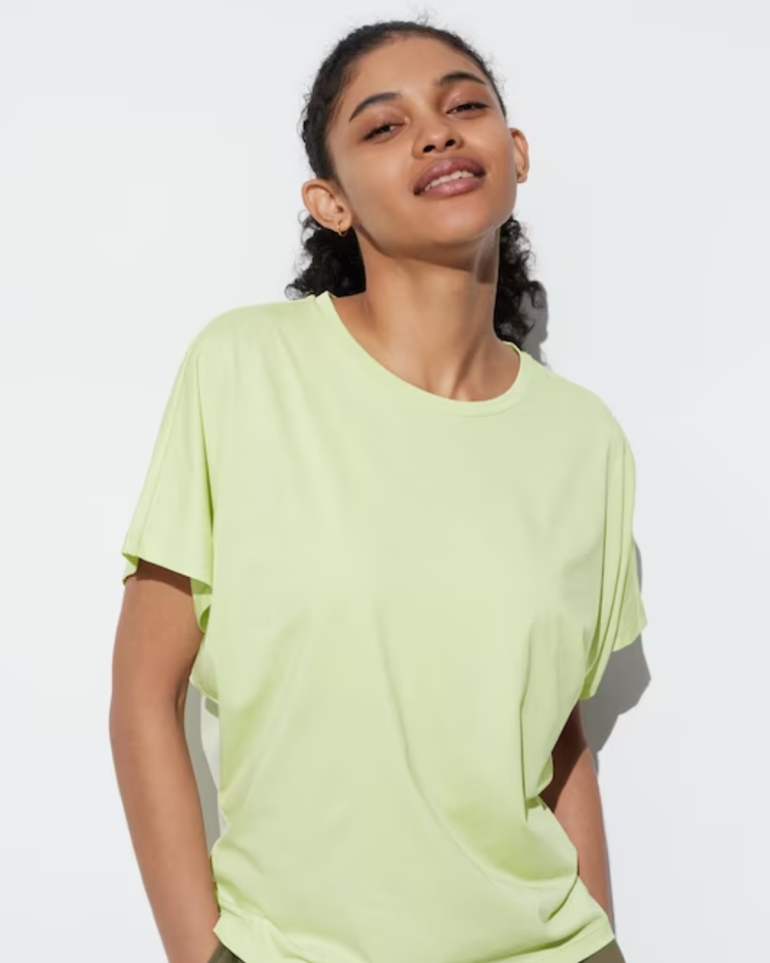 A person wearing a lime green drapey shirt